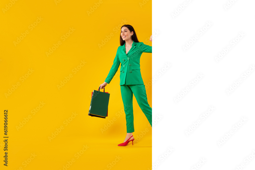 Shopping advertisement design. Happy stylish woman with shopper bags peeking from blank banner with space for ad, mockup Shopping advertisement design. Happy stylish woman with shopper bags peeking from blank banner with space for ad, mockup
