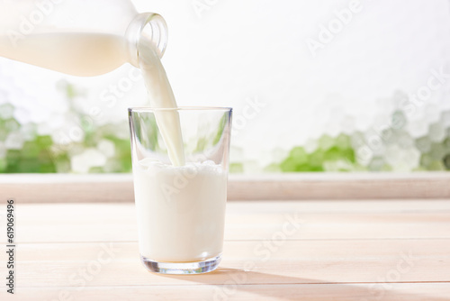 牛乳をガラスコップに注ぐ、健康的で爽やかな光 photo