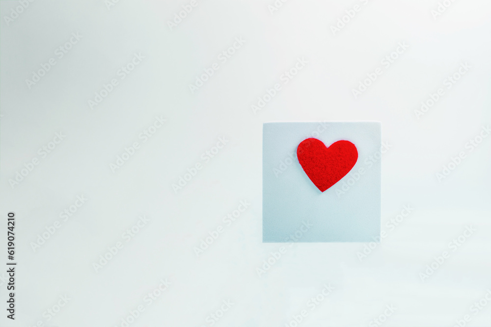 Light blue background of a blue podium in the shape of a cube with a red heart - a place for text