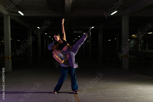 Hispanic attractive couple dancing ballet in the street