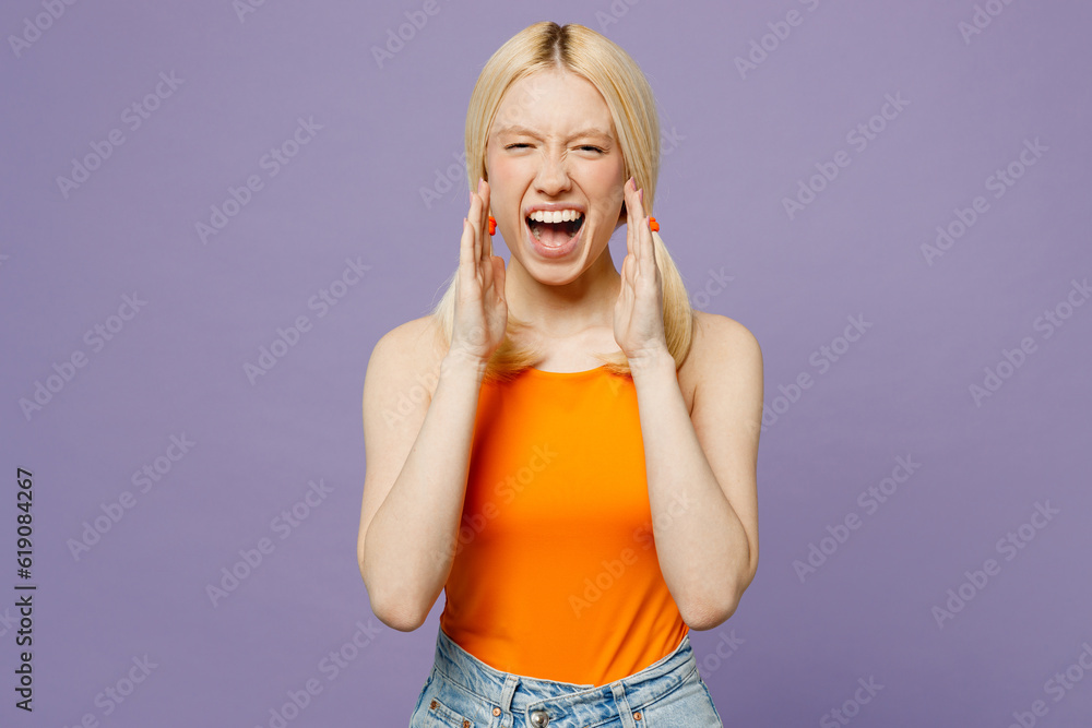 Young blonde woman wear orange tank shirt casual clothes scream sharing hot news about sales discount with hands near mouth isolated on plain pastel light purple background studio. Lifestyle concept.