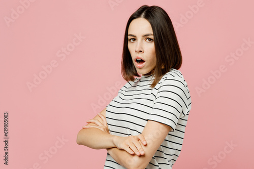 Side view indignant young sad caucasian woman she wears casual clothes t-shirt hold hands crossed folded look camera isolated on plain pastel light pink background studio portrait. Lifestyle concept.