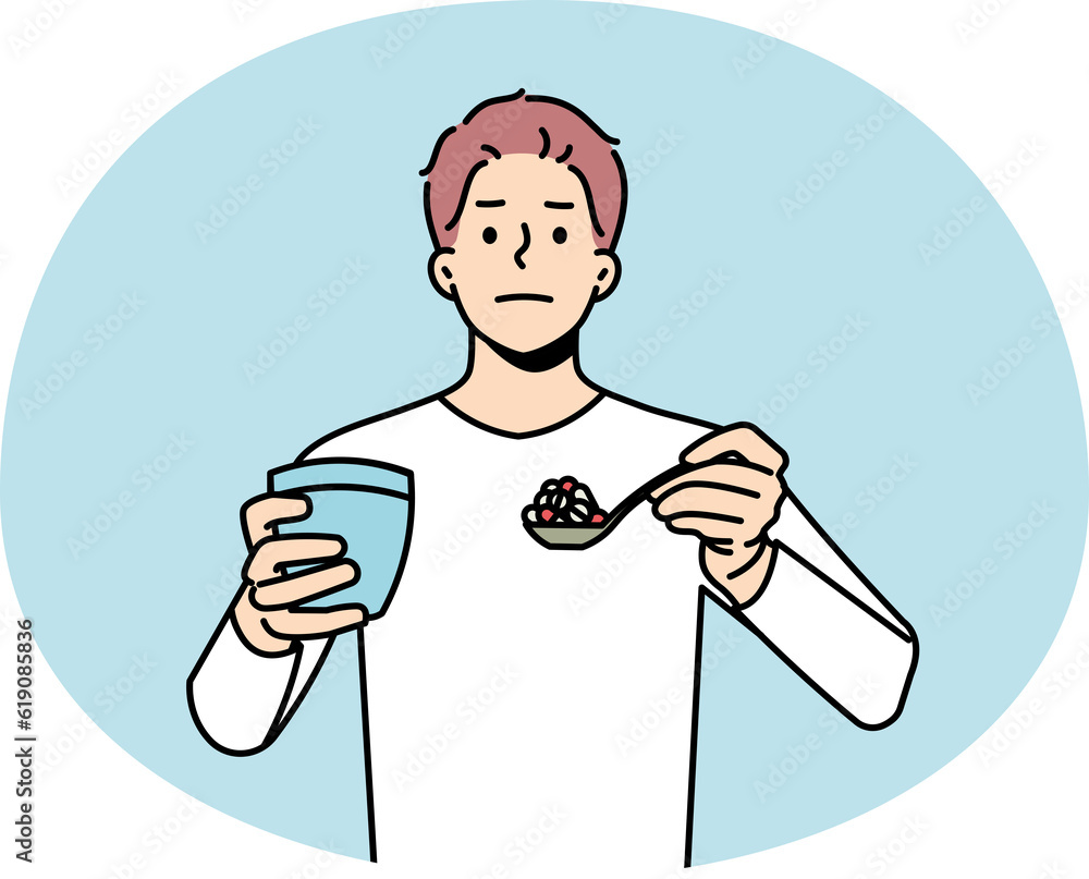 Man with spoonful of pills having medications Man with spoonful of pills having medications