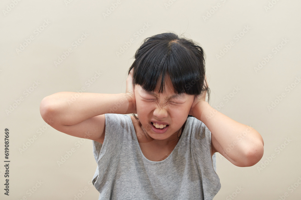 騒音を耐えない小学生の女の子の顔 騒音を耐えない小学生の女の子の顔