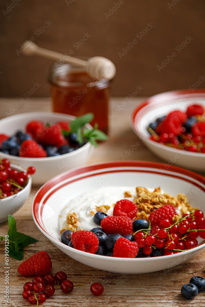 Yogurt with berries on wooden background. White plain greek yogurt with fresh berries and granola, top view. Healthy food, breakfast menu Yogurt with berries on wooden background. White plain greek yogurt with fresh berries and granola, top view. Healthy food, breakfast menu