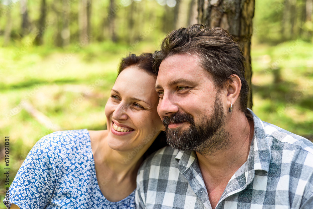 Portrait of young married couple sitting in the forest on a sunny day Portrait of young married couple sitting in the forest on a sunny day