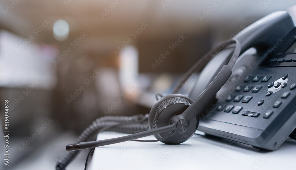 close up black headset with telephone in operation room to communicate with vendor or client for call center and hotline service concept close up black headset with telephone in operation room to communicate with vendor or client for call center and hotline service concept