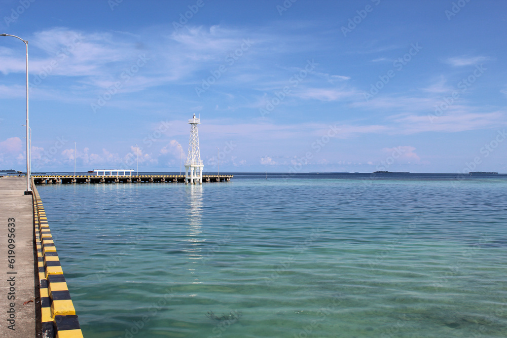 Karimun Jawa Port or Harbor, the empty dock or the paved road, with clear blue sea water and blue sky