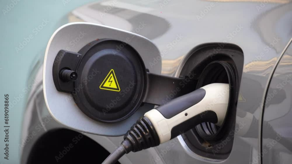electric eco car charges Close up of man charging electric car at charging station, new green energy concept electric eco car charges Close up of man charging electric car at charging station, new green energy concept