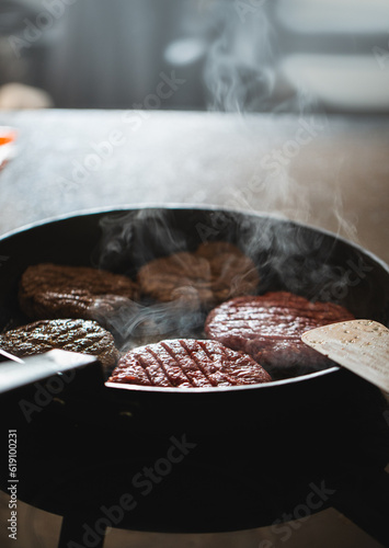 Frying pan with burgers / hamburger patties on high heat, home cooking cheeseburgers