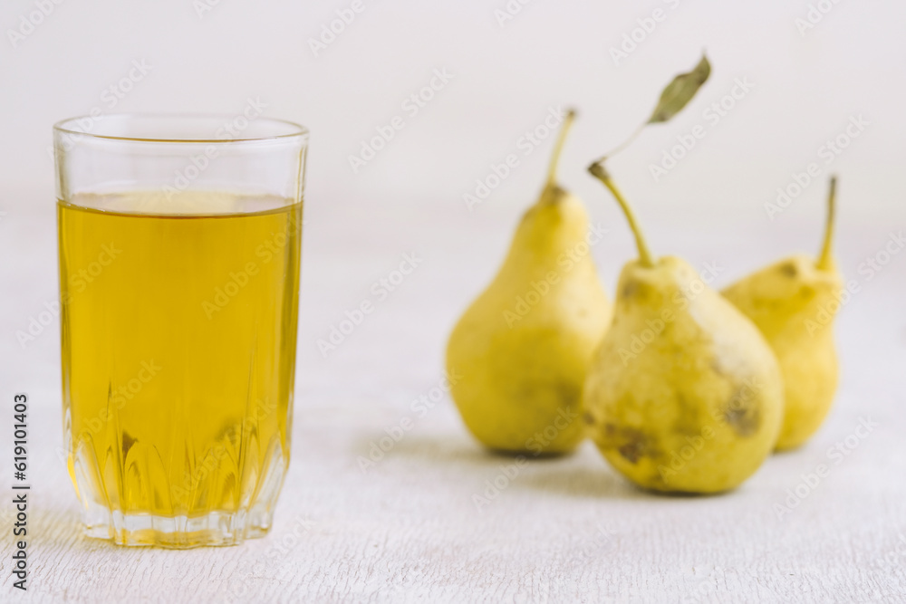 Juice of pears in a glass on a white wooden background Juice of pears in a glass on a white wooden background
