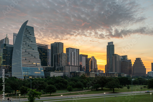 Downtown Austin at Sunrise with bright Yellow Sun in behind the Buildings © porqueno