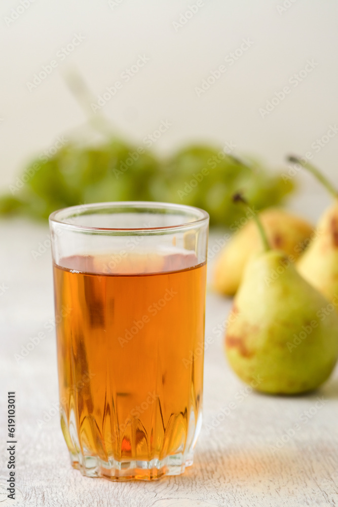 Juice of pears and grapes in a glass on a white wooden background Juice of pears and grapes in a glass on a white wooden background