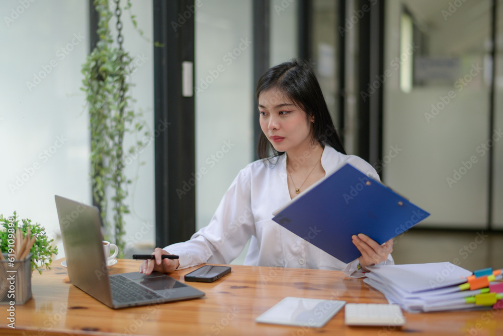 Young businesswoman working diligently, focus on working in front of the laptop. Analyze and plan new projects. Video conference. Young businesswoman working diligently, focus on working in front of the laptop. Analyze and plan new projects. Video conference.