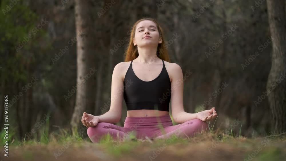 Redhead young woman meditating in a forest. Meditation in nature. Redhead young woman meditating in a forest. Meditation in nature.