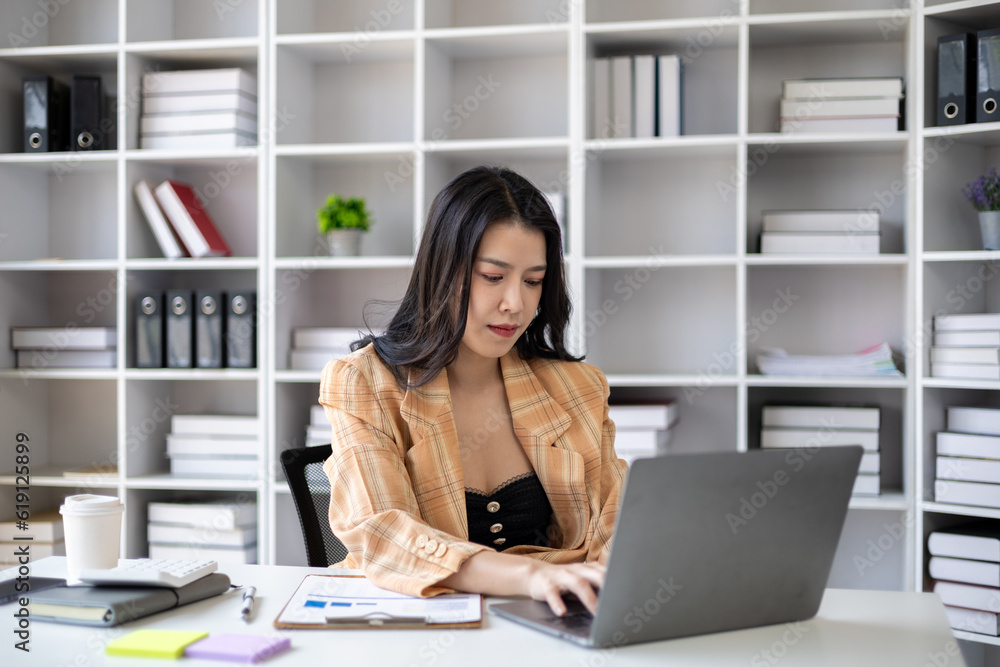 Young beautiful asian woman working in corporate office, businesswoman working in office attentively to grow and modernize start-up business, she is analyzing company's market and financial data. Young beautiful asian woman working in corporate office, businesswoman working in office attentively to grow and modernize start-up business, she is analyzing company's market and financial data.