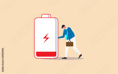 Tired and exhausted businessman, experiencing low energy, stress, and anxiety due to unhealthy work conditions, depicted with a low battery sign while looking down.