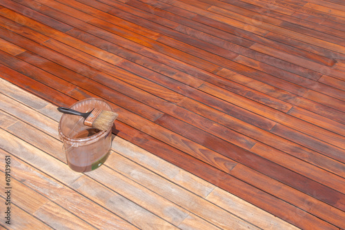 Wood deck refreshing, paint brush on the bucket with oil