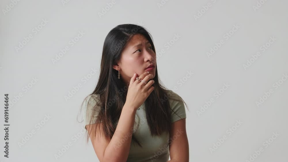 Young woman thinking and making decision isolated over white background in studio Young woman thinking and making decision isolated over white background in studio