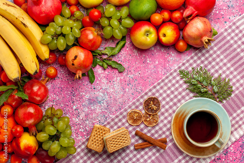 top view fresh fruit composition colorful fruits with cup of tea and waffle on pink background fruit fresh mellow color ripe
