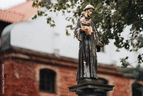 An old, dilapidated statue of St Anthony of Padua with Jesus in his arms.