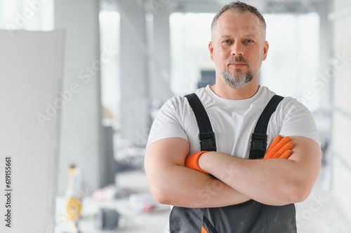 Portrait of a builder in the process of working on a construction site indoors