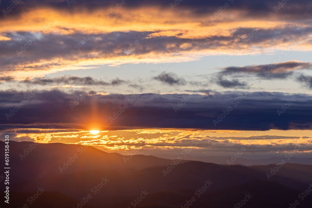 Winter Sunset through lines of clouds over Blue Ridge Mountains