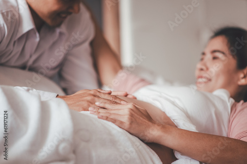 Love of family, motherhood, parenthood and expectation concepts. Asian woman and husband caressing his girlfriend belly and feeling the movements of the baby.