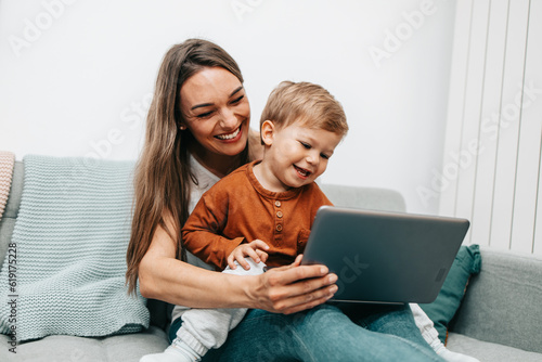 Foto Happy middle age woman playing with her little son at home