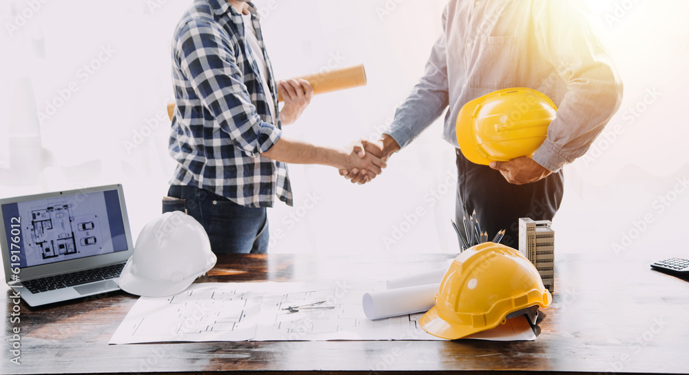 Construction and structure concept of Engineer or architect meeting for project working with partner and engineering tools on model building and blueprint in working site, contract for both companies. Construction and structure concept of Engineer or architect meeting for project working with partner and engineering tools on model building and blueprint in working site, contract for both companies.