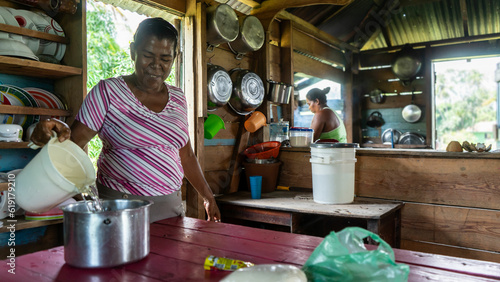 Afro-descendant Caribbean cooking with pure water in her humble home in the northern Caribbean of Nicaragua photo