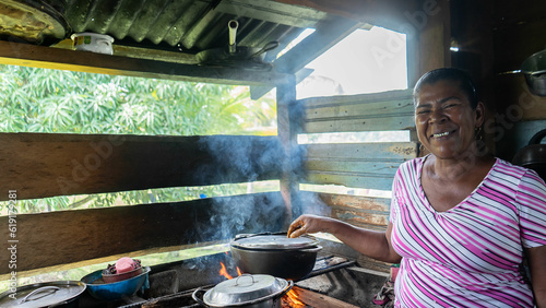 Native African woman smiling and looking at the camera while cooking in her home in Nicaragua's Caribbean photo