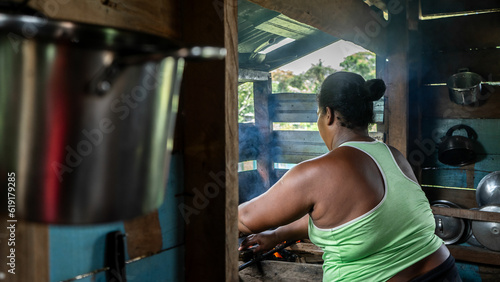 Nicaraguan Caribbean mestizo woman washing dishes in a humble home in Nicaragua photo