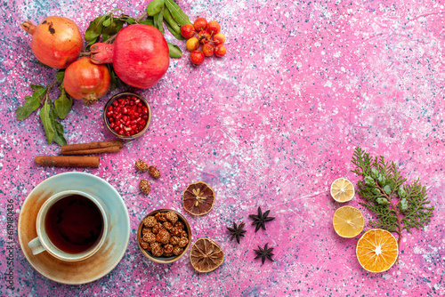 top view fresh pomegranate with green leaves and cup of tea on pink background fruits fresh mellow autumn tree plant color