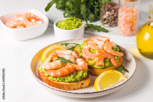 Shrimps on toast with avocado and lemon. Breakfast concept. Bruschetta. 