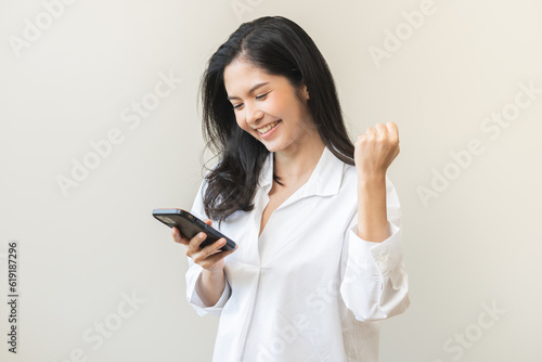 Happy asian young woman using mobile smart phone, read good news online feel excited getting offer, great positive surprise, celebrate success on smartphone. Businesswoman isolated on white background
