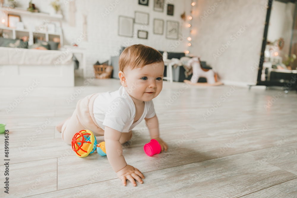 baby 6-9 months old playing with a colorful rainbow toy pyramid sitting in a white sunny bedroom. Toys for small children. Children's interior. A child with an educational toy. baby 6-9 months old playing with a colorful rainbow toy pyramid sitting in a white sunny bedroom. Toys for small children. Children's interior. A child with an educational toy.