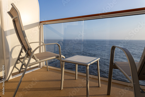 Cruise ship balcony with two chairs and table.