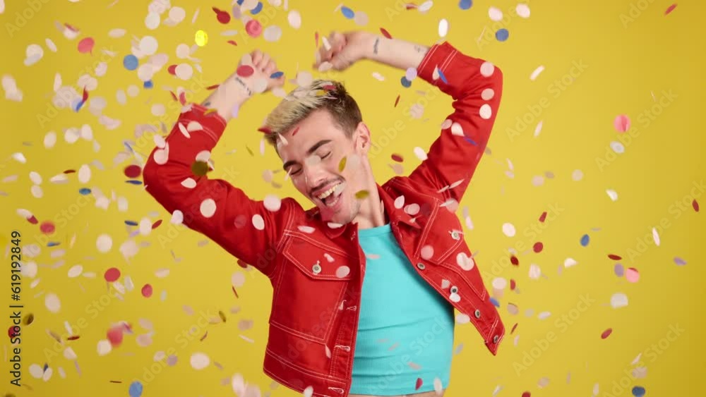 Happy gay man surrounded by confetti in the air