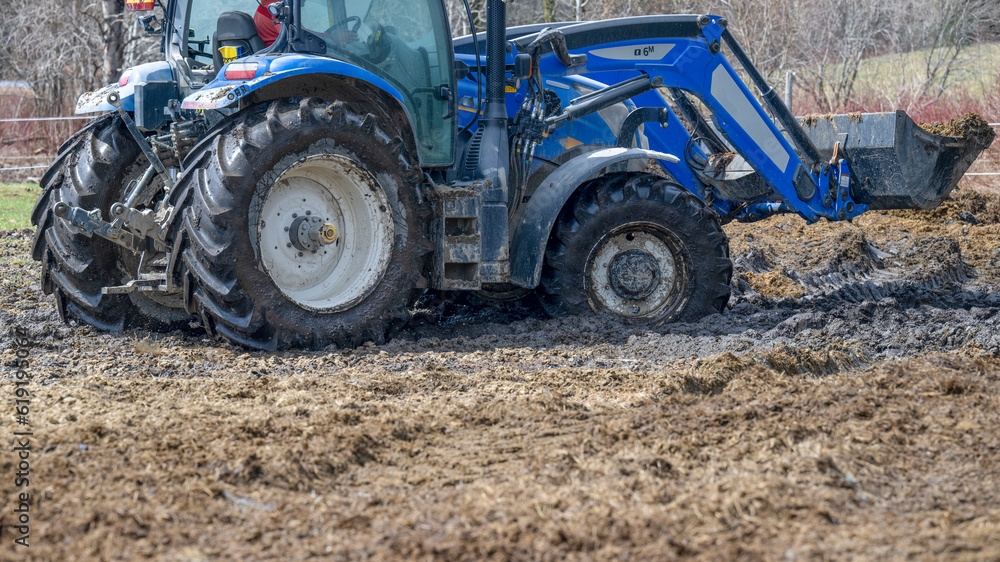 A tractor moving horses manure in a field A tractor moving horses manure in a field