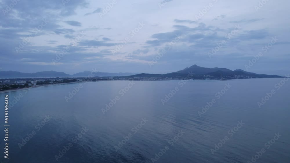 Pedestal rising drone shot over a Mediterranian bay at sunrise on a cloudy day Pedestal rising drone shot over a Mediterranian bay at sunrise on a cloudy day