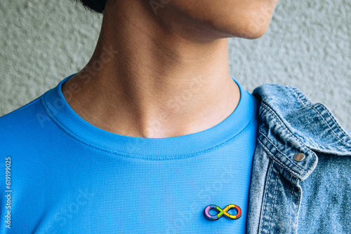 Papier peint Teenage boy with autism infinity rainbow symbol sign metallic pin brooch on t-shirt
