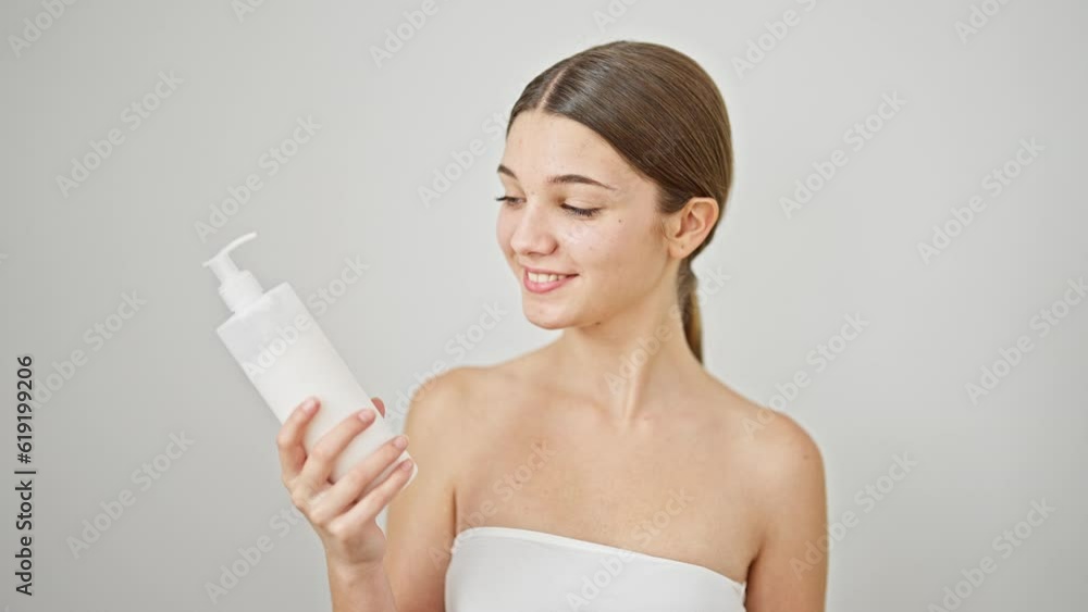 Young beautiful girl smiling confident holding cream bottle over isolated white background Young beautiful girl smiling confident holding cream bottle over isolated white background