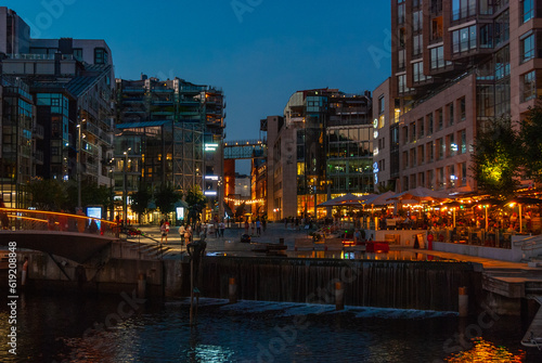 Photography Illuminated Akker Brygge, a modern district in Oslo city center at night and in