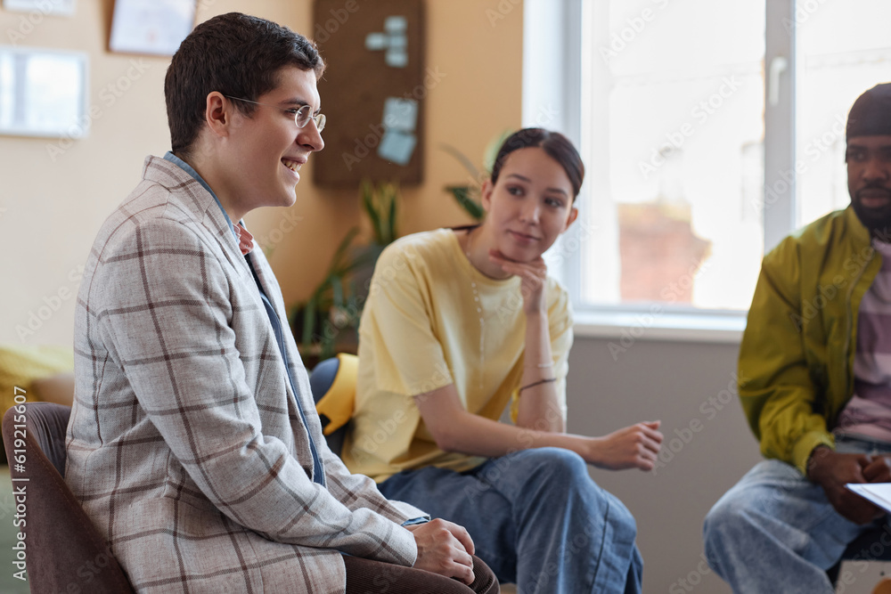 Young man talking to people during psycho session in office Young man talking to people during psycho session in office