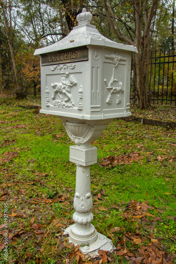 Victorian cast iron pedestal mailbox with carved figure of a postman on