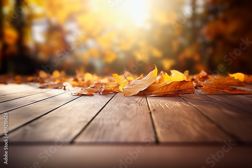 Wooden table with fallen leaves during autumn with background of trees of different autumn colors