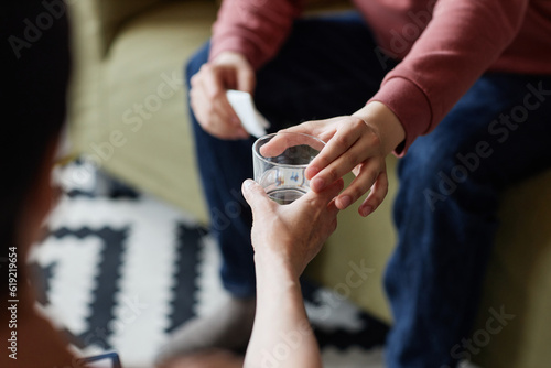 Close-up of psychologist giving glass of water to patient during psychotherapy session