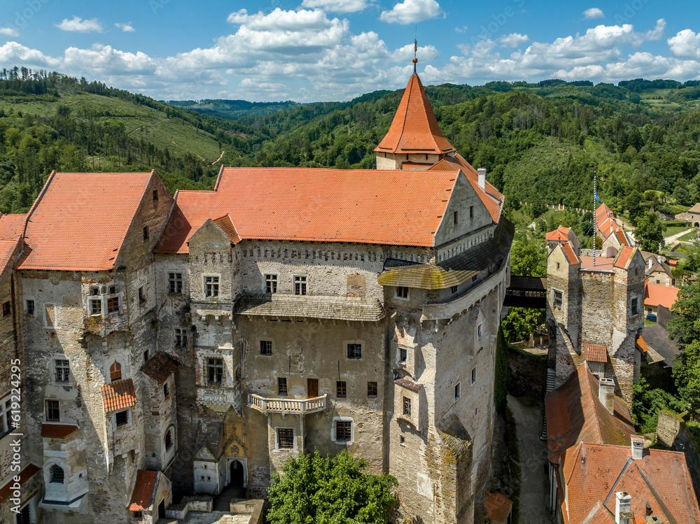 Close up aerial view of Pernstejn castle with Gothic palace red roof, rectangular and round towers, barbican, forward gun platform in Moravia