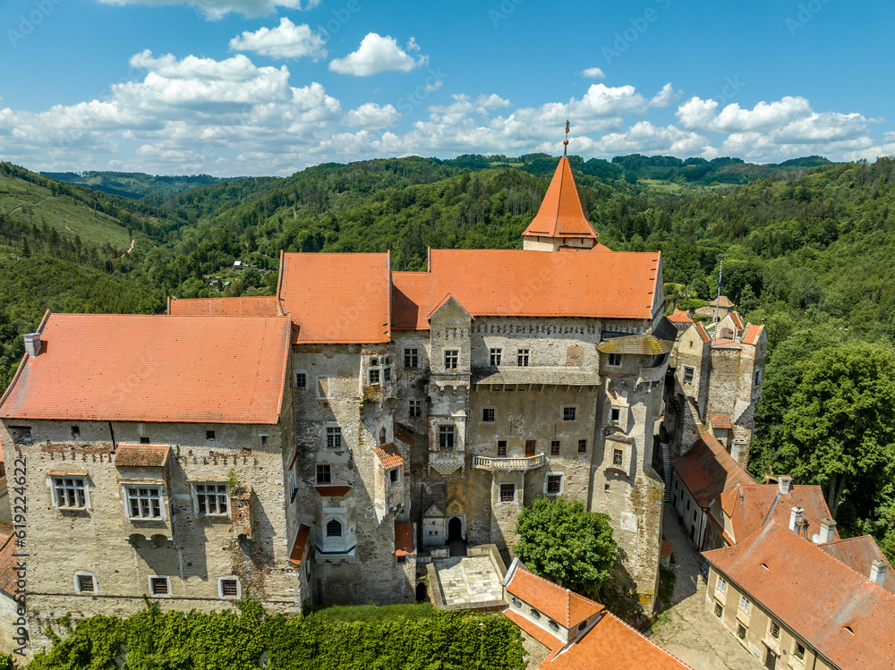 Close up aerial view of Pernstejn castle with Gothic palace red roof, rectangular and round towers, barbican, forward gun platform in Moravia